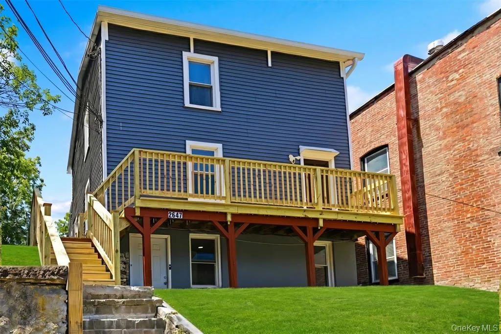 Blue two-story house at 2647 E Main Street in Wappingers Falls with a new wood deck across the front