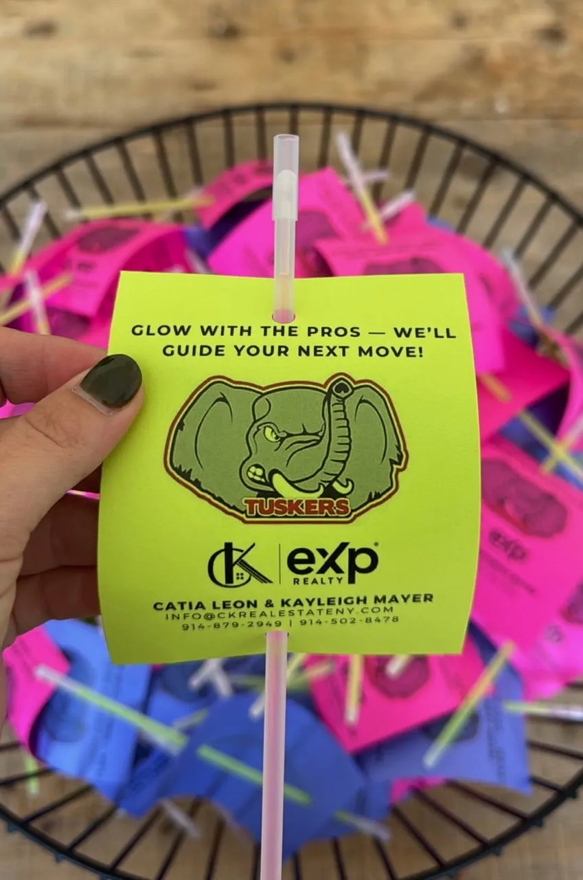 Glow stick with a Tuskers CK Team card over a basket of glow sticks