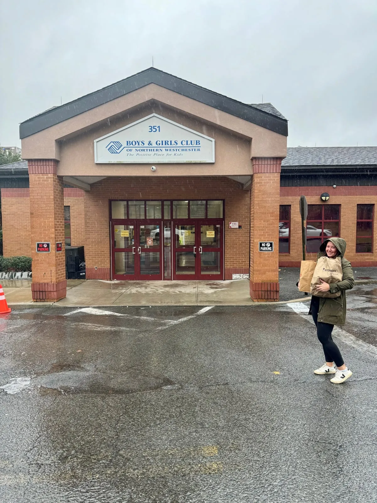 Team member carrying holiday gift bags outside the Boys & Girls Club of Northern Westchester