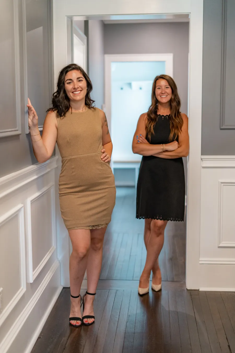 Kayleigh and Catia standing together in the doorway of a bright hallway