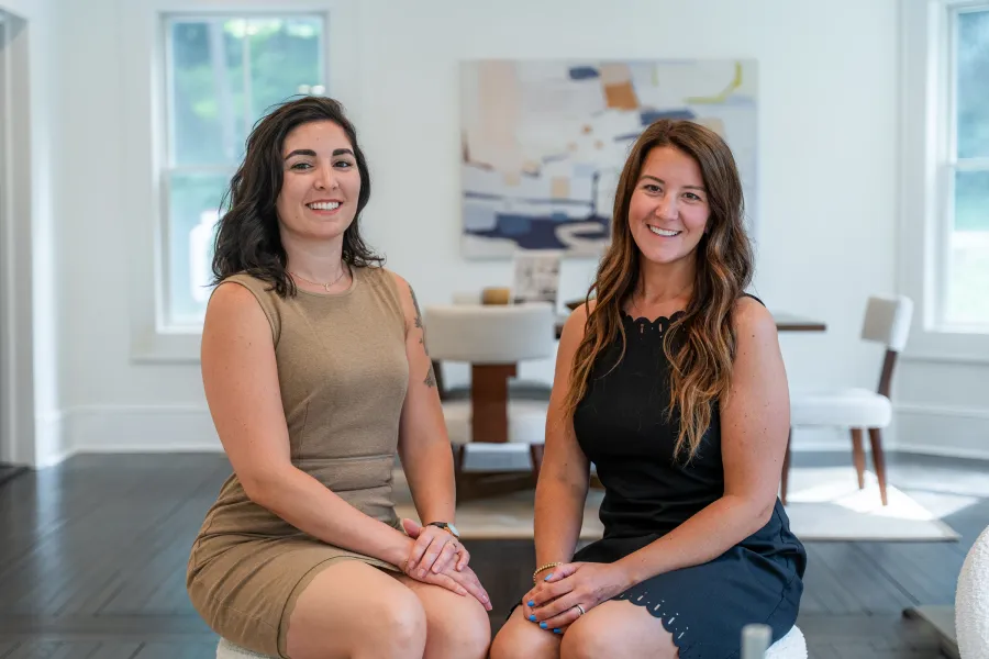 Kayleigh and Catia seated side by side in a bright living room
