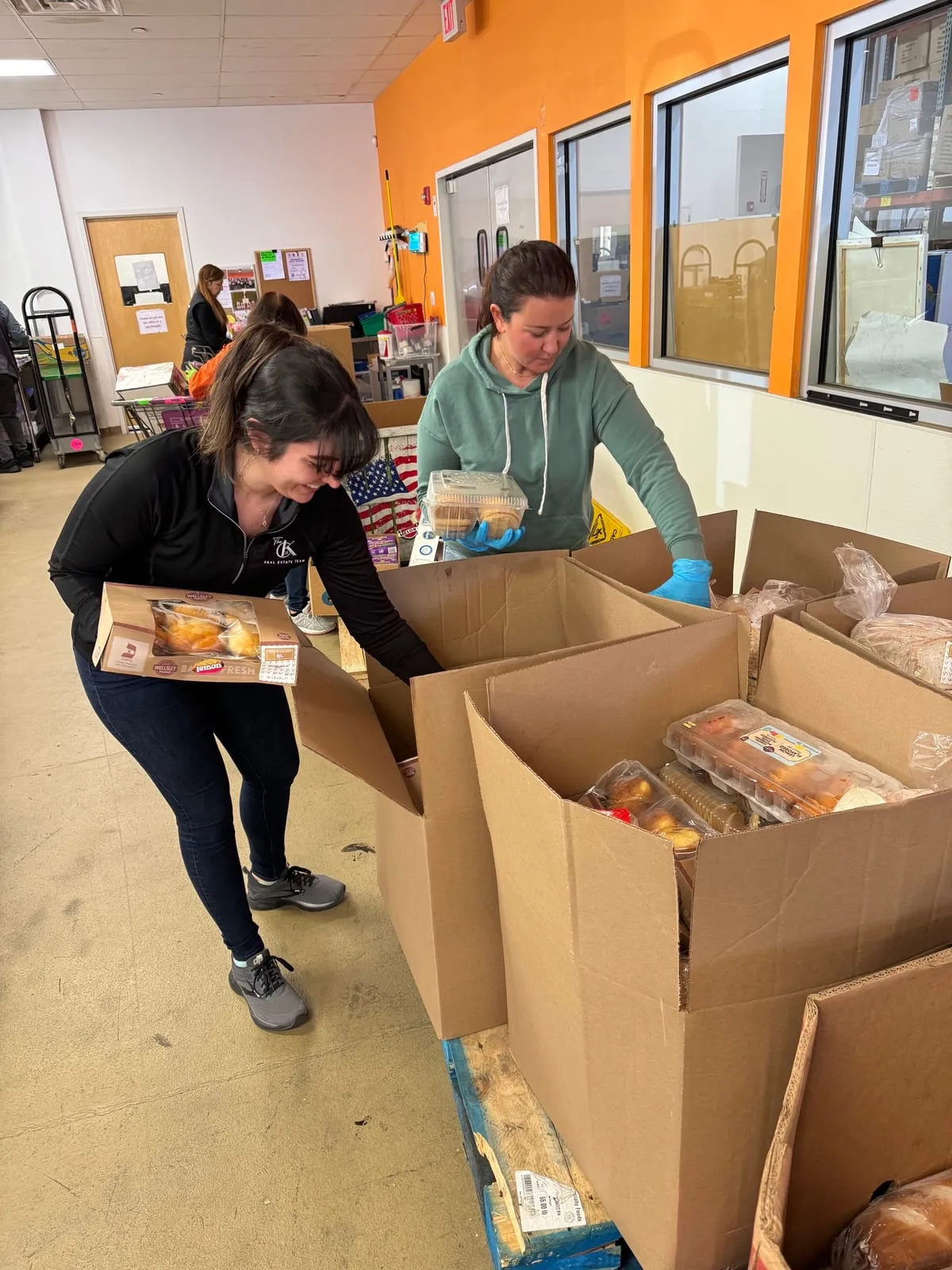 Volunteers packing donated baked goods into boxes at a food pantry