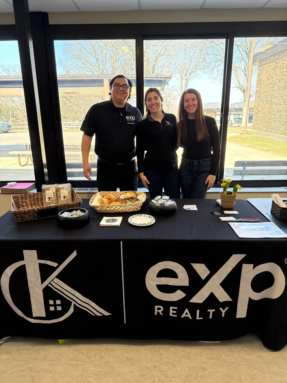 Three people behind a pastry table for teachers at Primrose Elementary